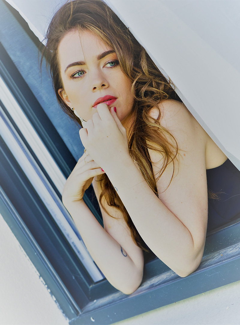 shooting photo femme maquillée accoudée à une fenêtre